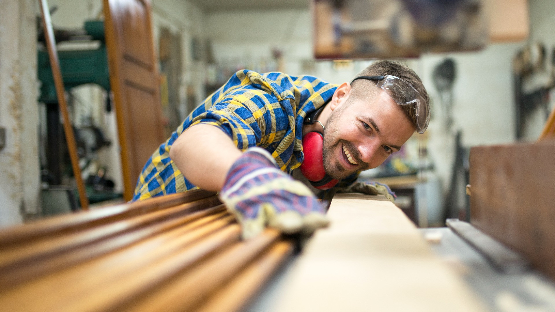 portrait-experienced-carpenter-worker-cutting-wood-plank-machine-his-woodworking-workshop